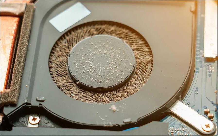 Laptop fan covered with dust and debris.